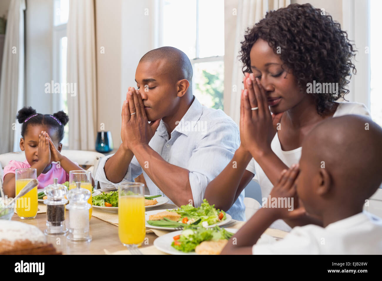Glückliche Familie sagen Gnade vor Mahlzeit Stockfoto