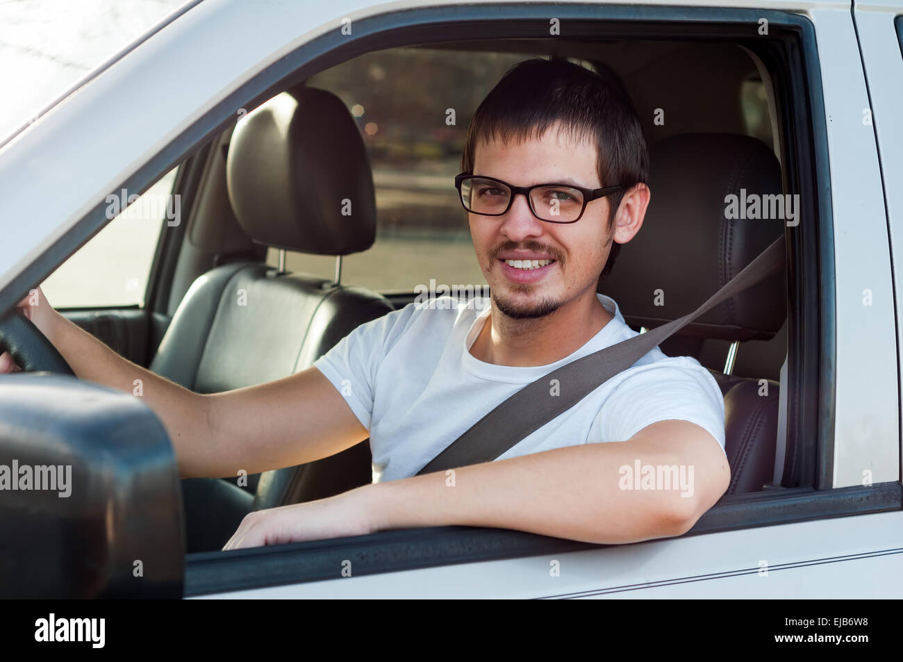 Männlichen europäischen guter Fahrer lächelt in seinem Auto Stockfoto