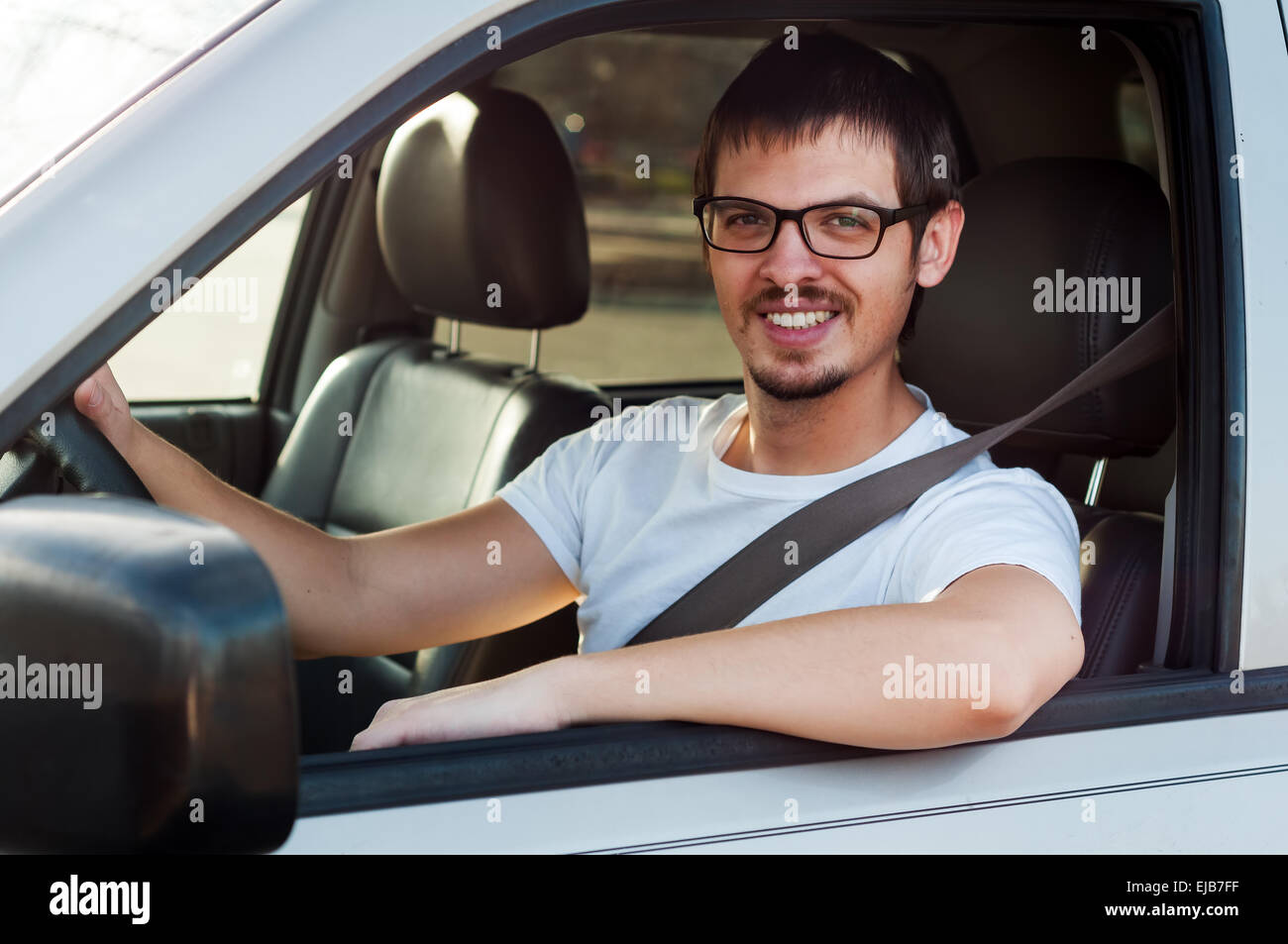 Männlichen kaukasischer guter Fahrer lächelt in seinem Auto Stockfoto