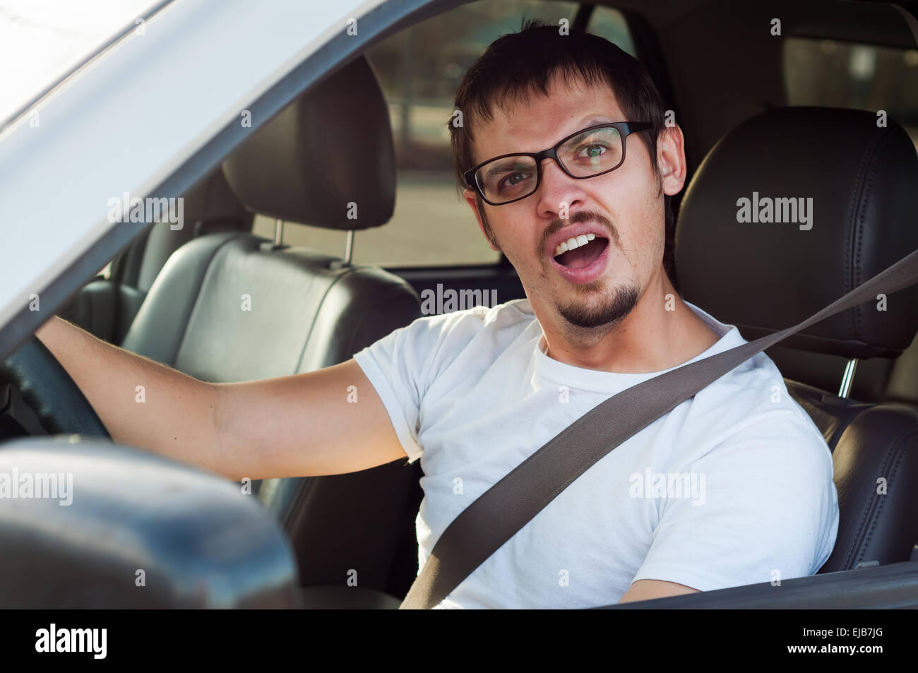 Männliche dummes Gesicht europäischen Fahrer öffnet seinen Mund Stockfoto