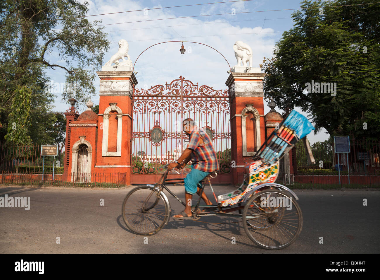 Rikscha-Fahrer auf Trike vor den Toren von Cooch Behar Palast, auch genannt der Victor-Jubiläums-Palast, in Westbengalen, Indien Stockfoto