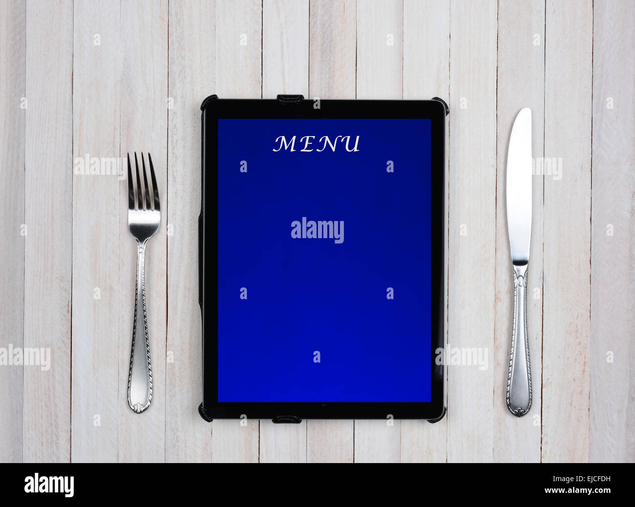 Tablet-Computer mit Menü auf dem Bildschirm auf einem rustikalen Holz Restauranttisch. Elektronische Essen bestellen Servicekonzept. Stockfoto