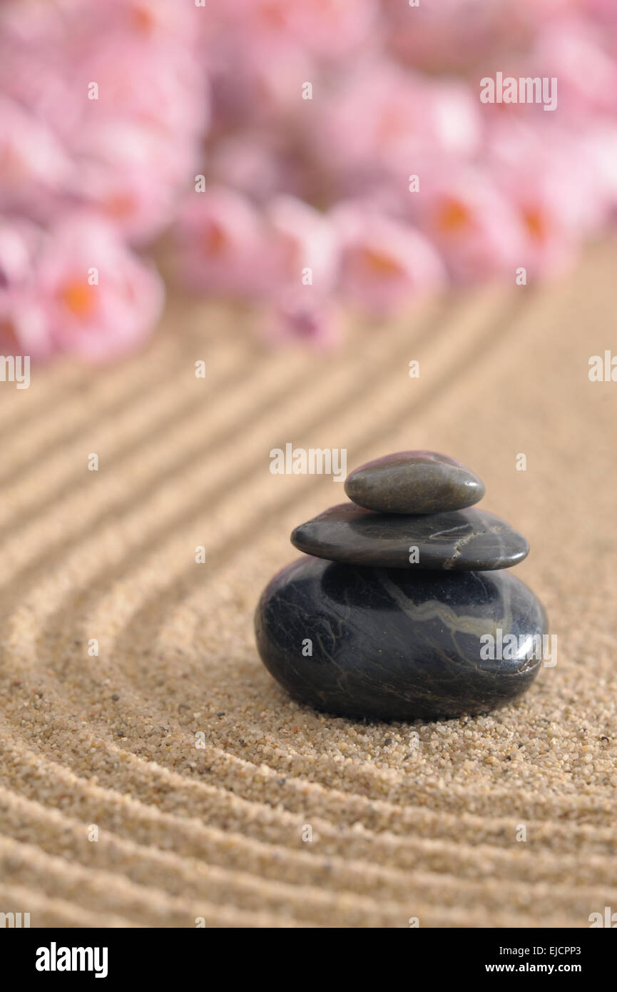 Zen-Garten im Sand mit gestapelten Steinen Stockfoto