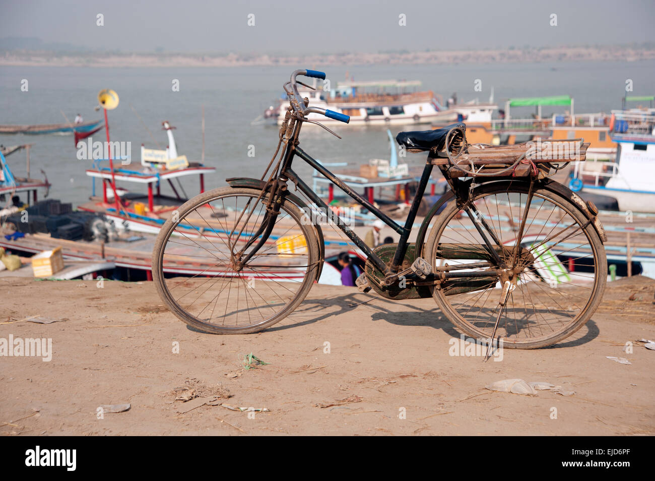 Ein altes Fahrrad steht vor Ladung Baots an den Ufern des Flusses Ayeyarwady in Mandalay Myanmar Burma Stockfoto