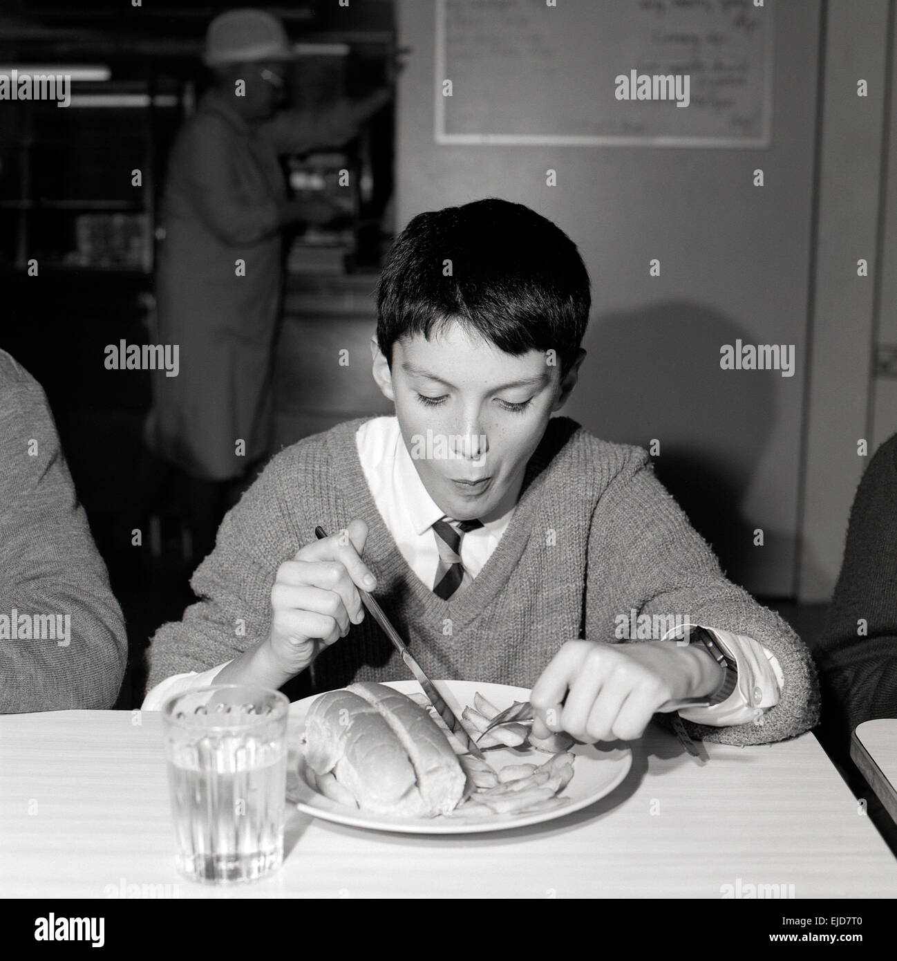 Eine Schwarze Und Weisse 90er Jahre Archivierung Bild Eines Jungen Das Tragen Einer Schuluniform Sitzen An Einem Tisch Essen Schule Abendessen Von Wurstchen Und Chips In Der Cafeteria An Der Ysgol Pantycelyn