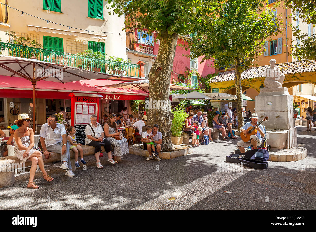 Menschen hören Straßenmusiker auf dem kleinen Platz in der Altstadt von Menton, Frankreich. Stockfoto