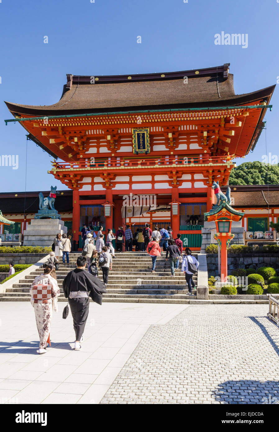 Traditionell gekleidete japanisches Paar zu Fuß in Richtung der Turmtor am Fushimi Inari Schrein, Kyoto, Japan Stockfoto