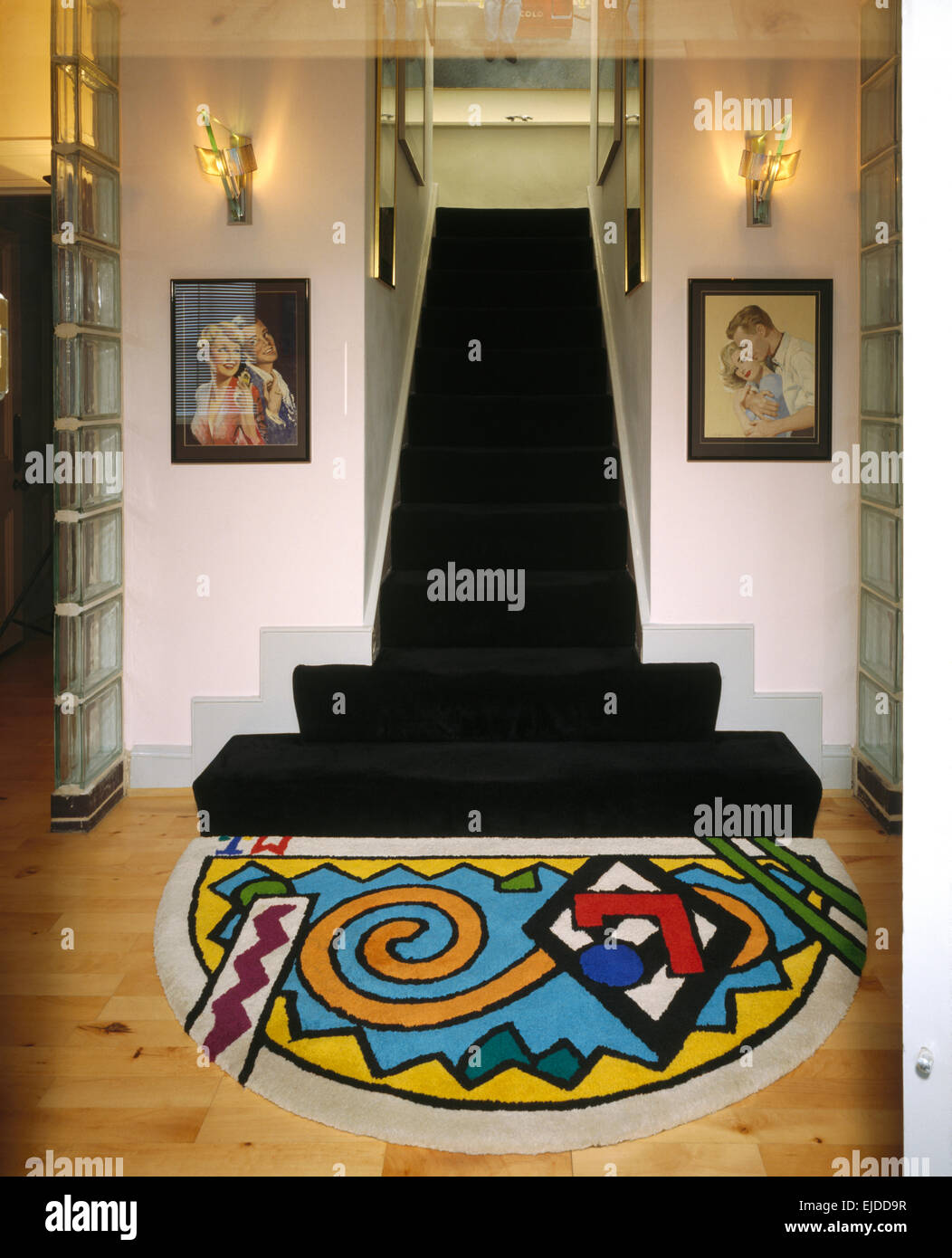 Bunt gemusterten Teppich am Fuße der Treppe mit schwarzem Teppich in einem 80er Jahre Halle Stockfoto