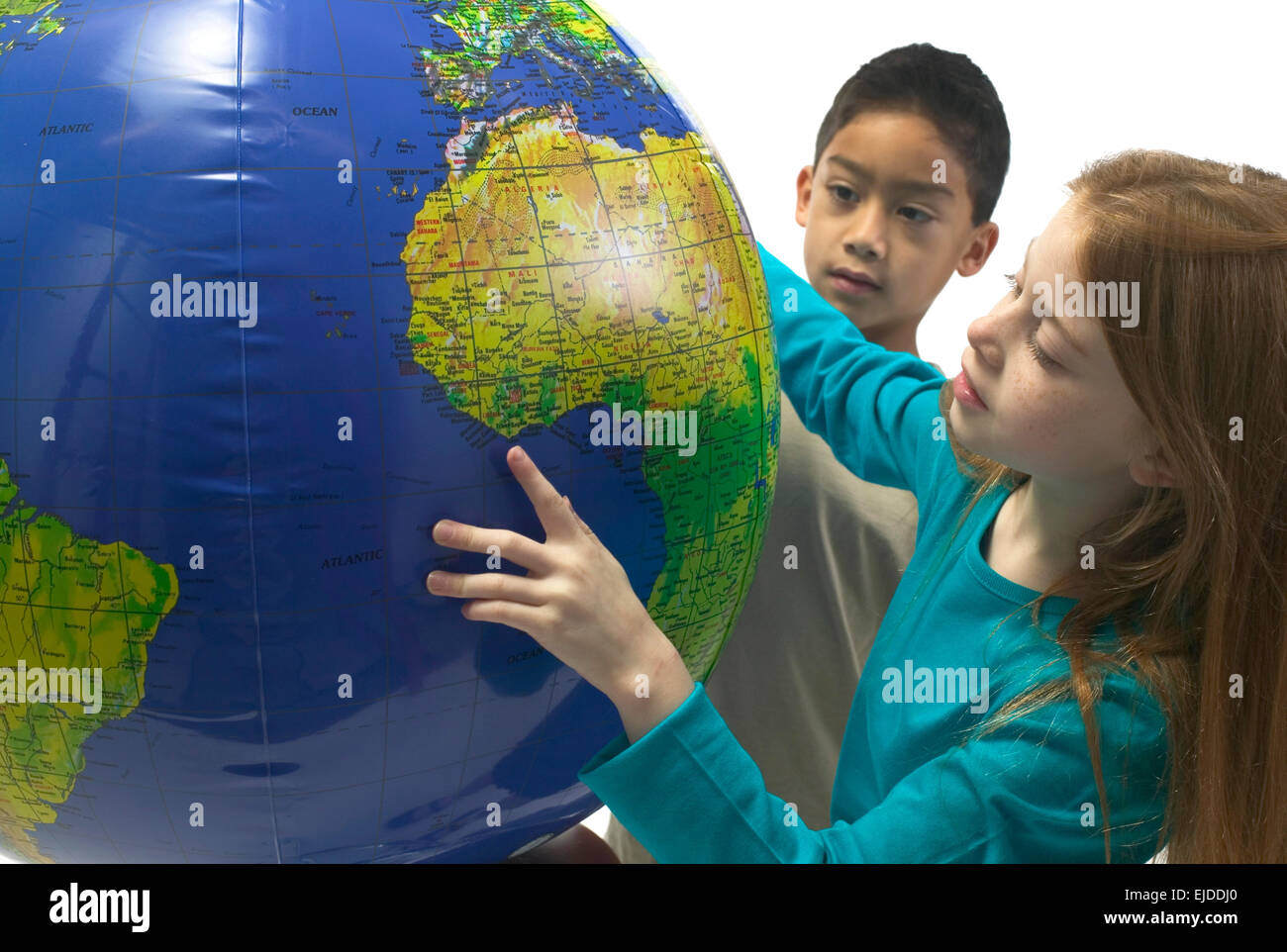 Porträt eines kaukasischen Mädchens und ein Hispanic junge Afrika auf ein  aufblasbarer Wasserball Globus auf einem weißen Hintergrund suchen. T  Stockfotografie - Alamy