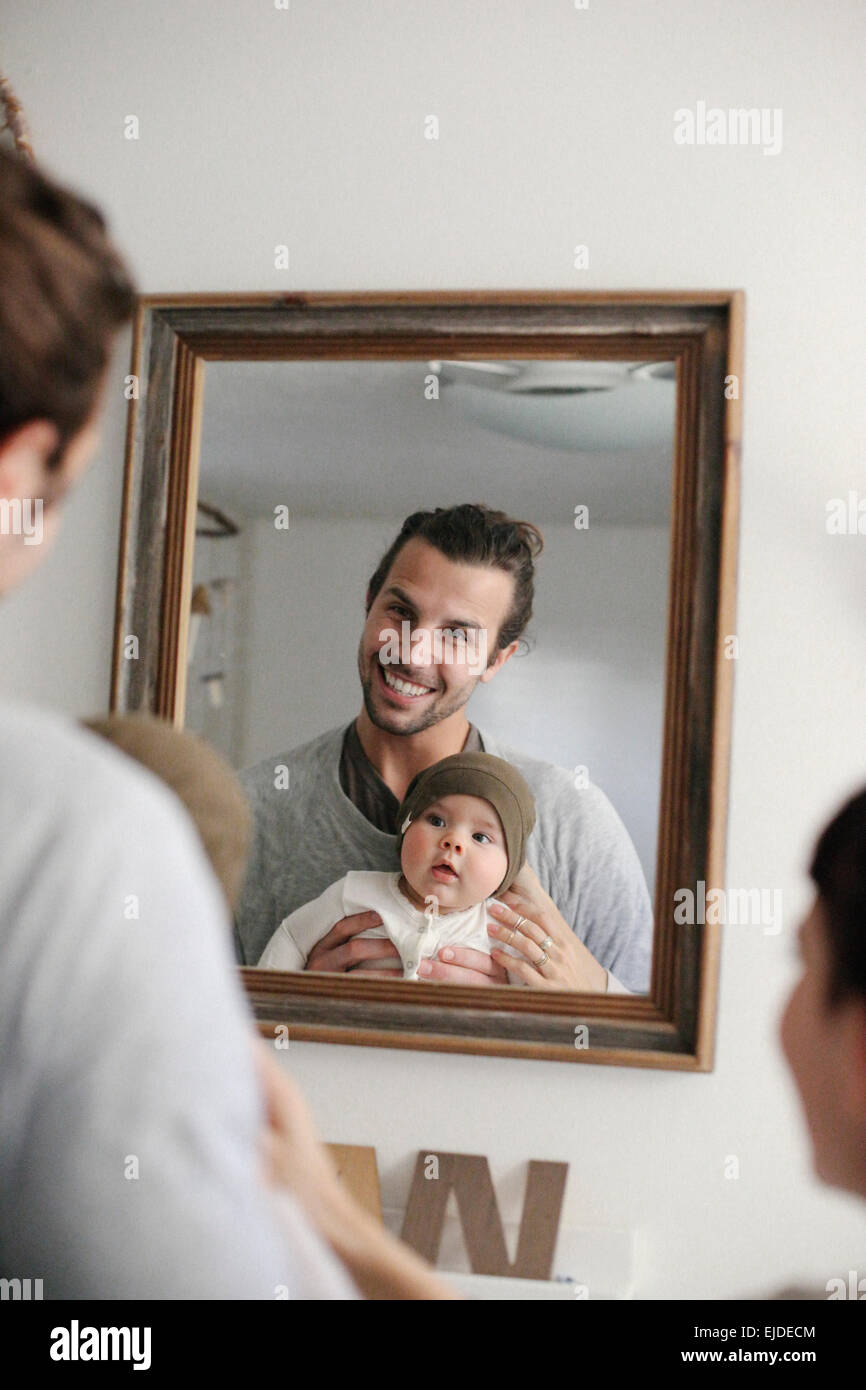Eine Mutter und Vater zu ihrem Kind, in den Spiegel. Stockfoto