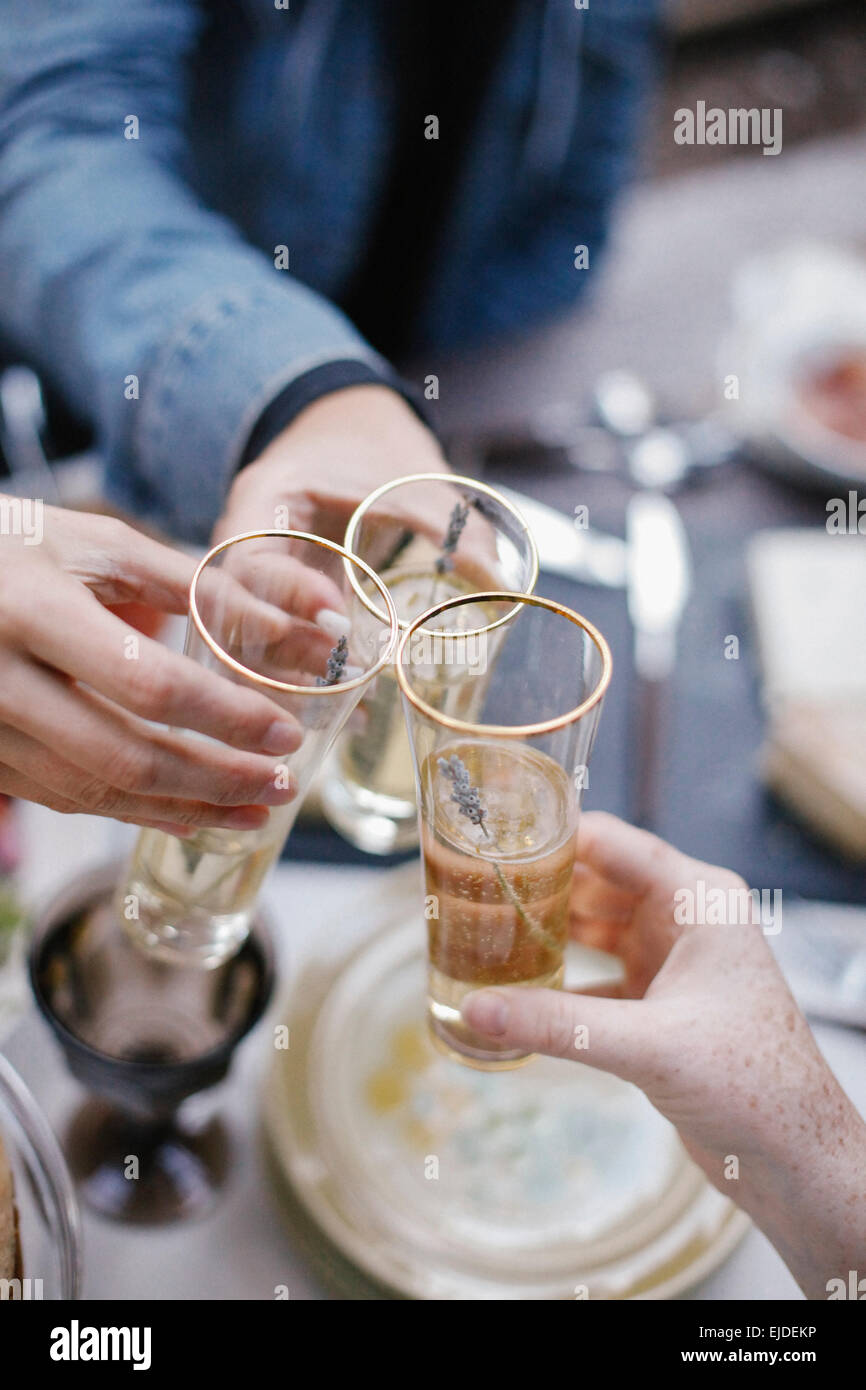 Drei Menschen, die einen Toast, Gläser klirren. Stockfoto