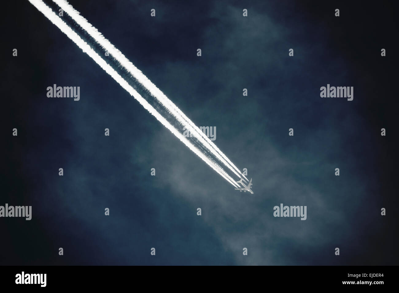 Ein Strahl mit einem klaren Kondensation oder Dampf Trail oder Kondensstreifen über einen tiefblauen Himmel. Stockfoto