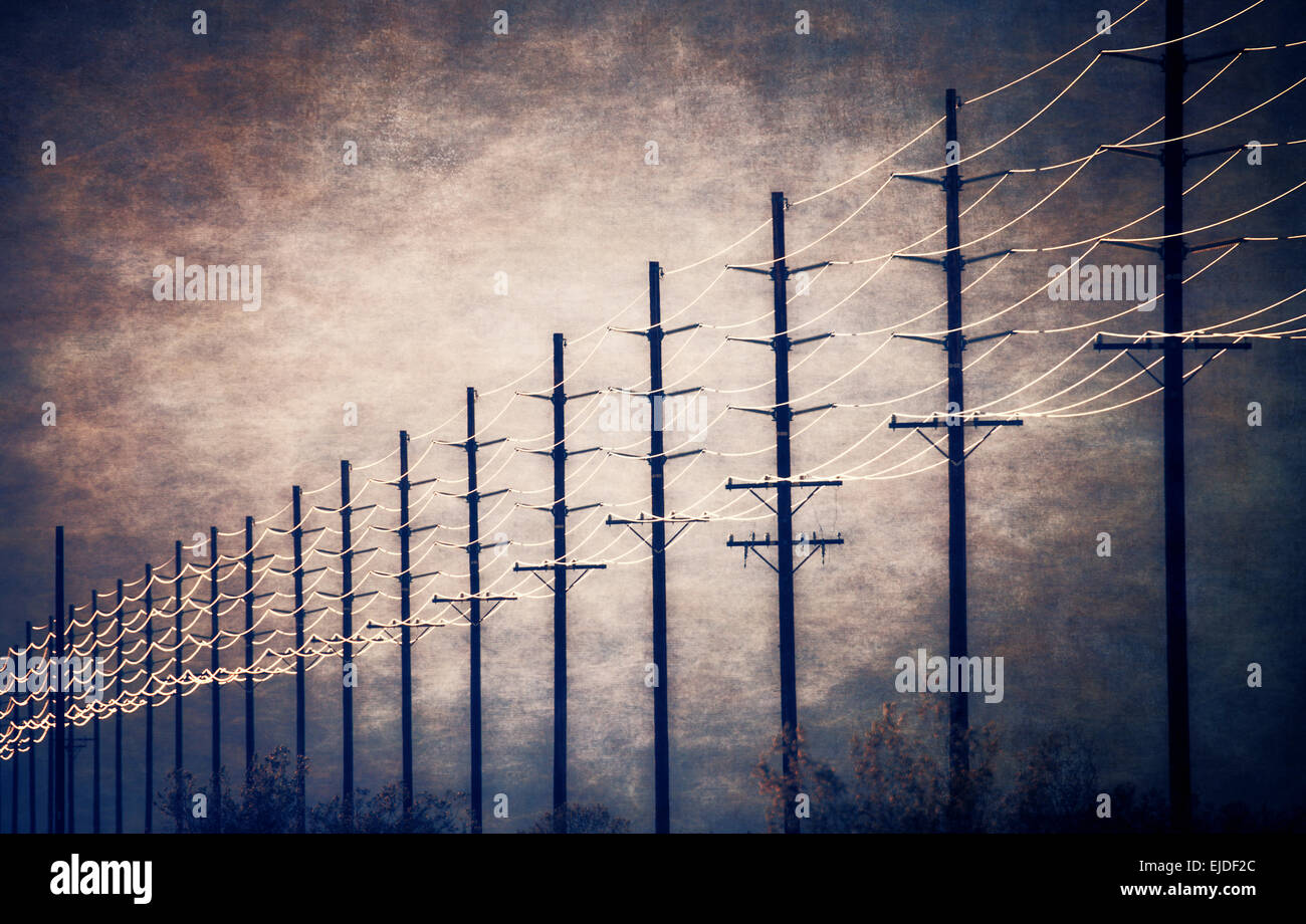 Stromleitungen in regelmäßigen Abständen in die Ferne gegen einen Patch der clearing-Himmel und Wolken zu erreichen. Stockfoto