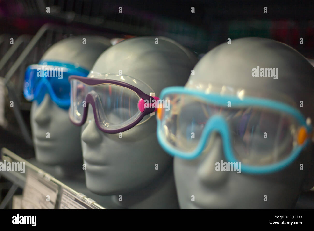 Dummy-Köpfe aufgereihten Modellierung Kappen mit Sportbrille auf einem Stand am Markt Stockfoto