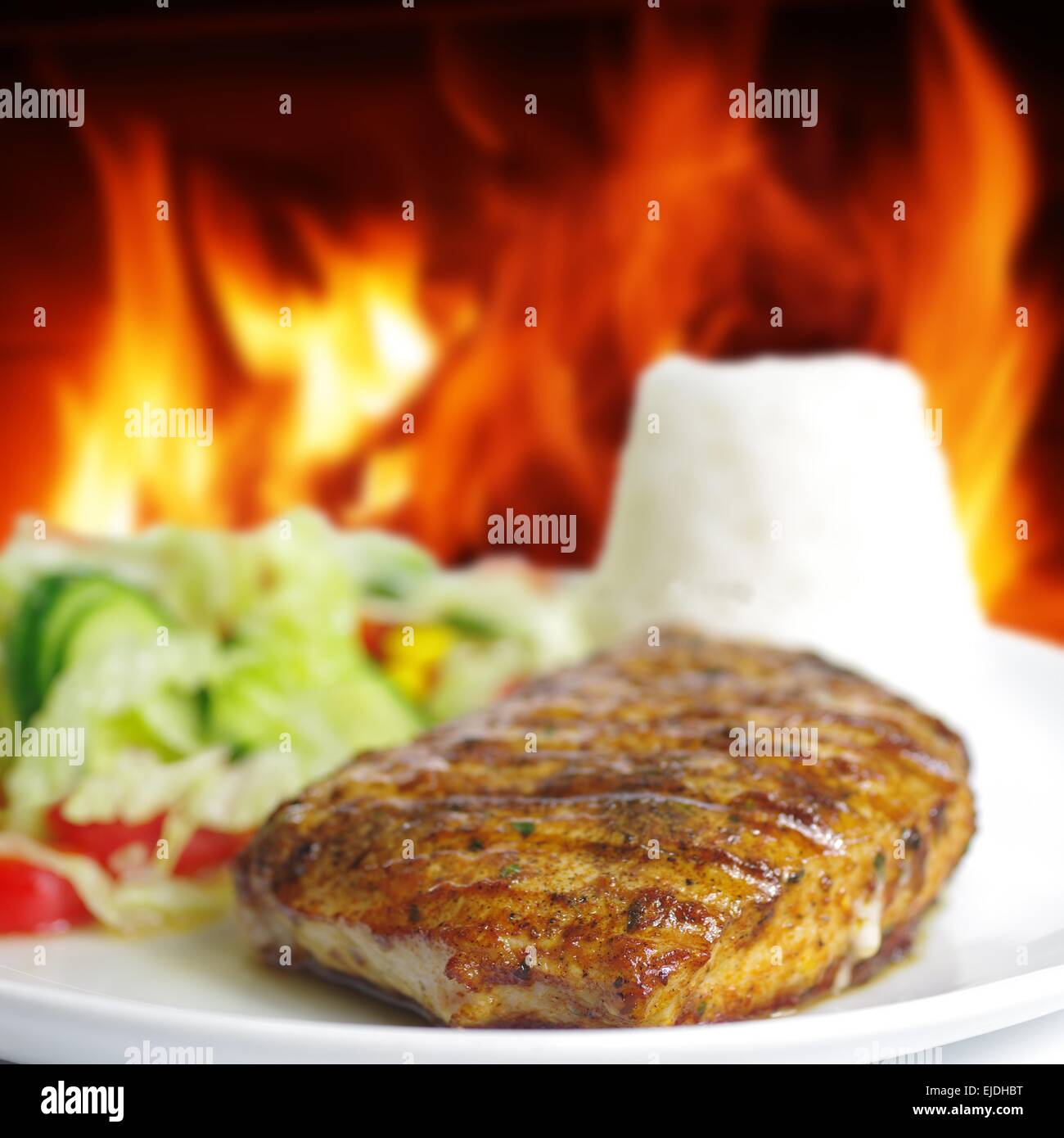 Steak mit Reis und Gemüse auf Feuer Hintergrund Stockfoto