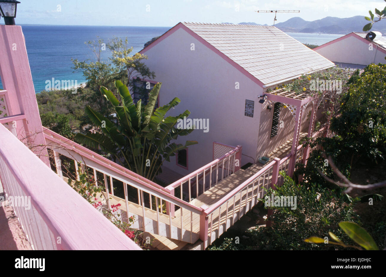 Blick vom Balkon des gemalten Holzsteg zum karibischen Häuschen am Meer Stockfoto