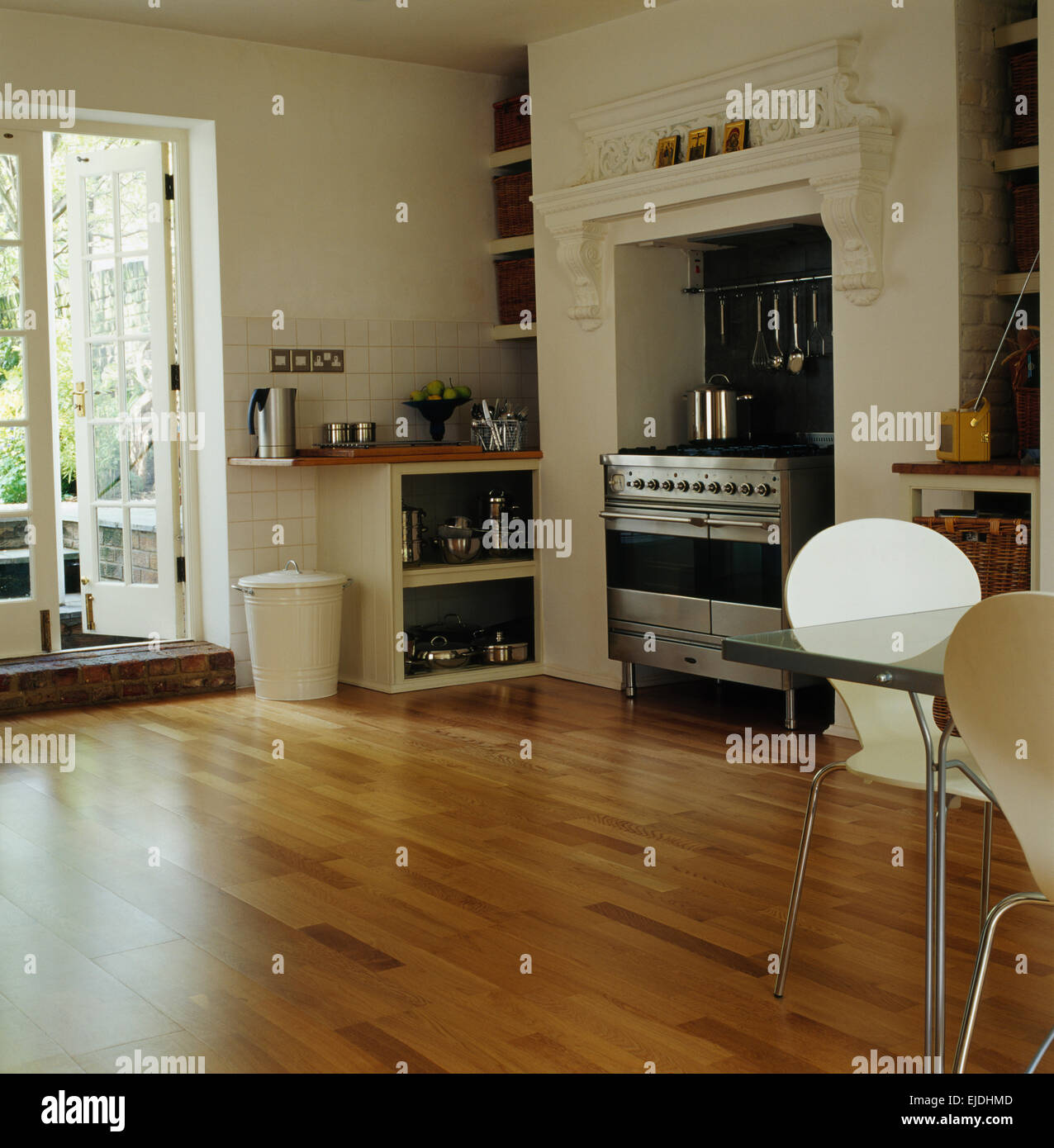 Holzböden und französische Fenster im Speisesaal moderne Küche mit Edelstahl-Herd Stockfoto
