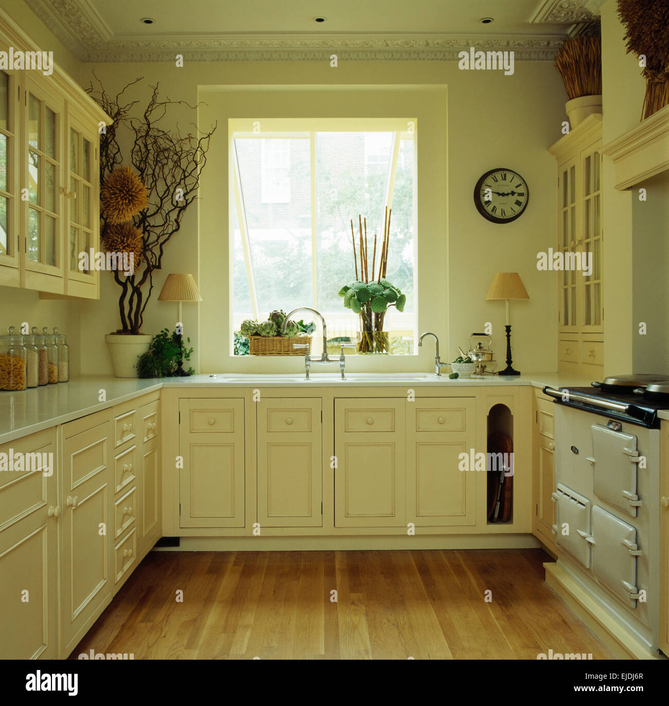 Holzboden und weiße Aga in kleinen cremefarbenen Stadthaus Küche Stockfoto