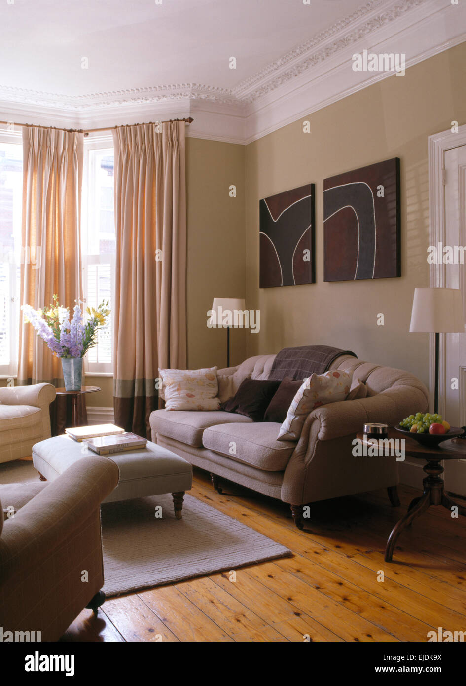 Blasse graue Sofa und Ottomane in Stadthaus Wohnzimmer mit grauen Teppich auf polierten Dielen Stockfoto
