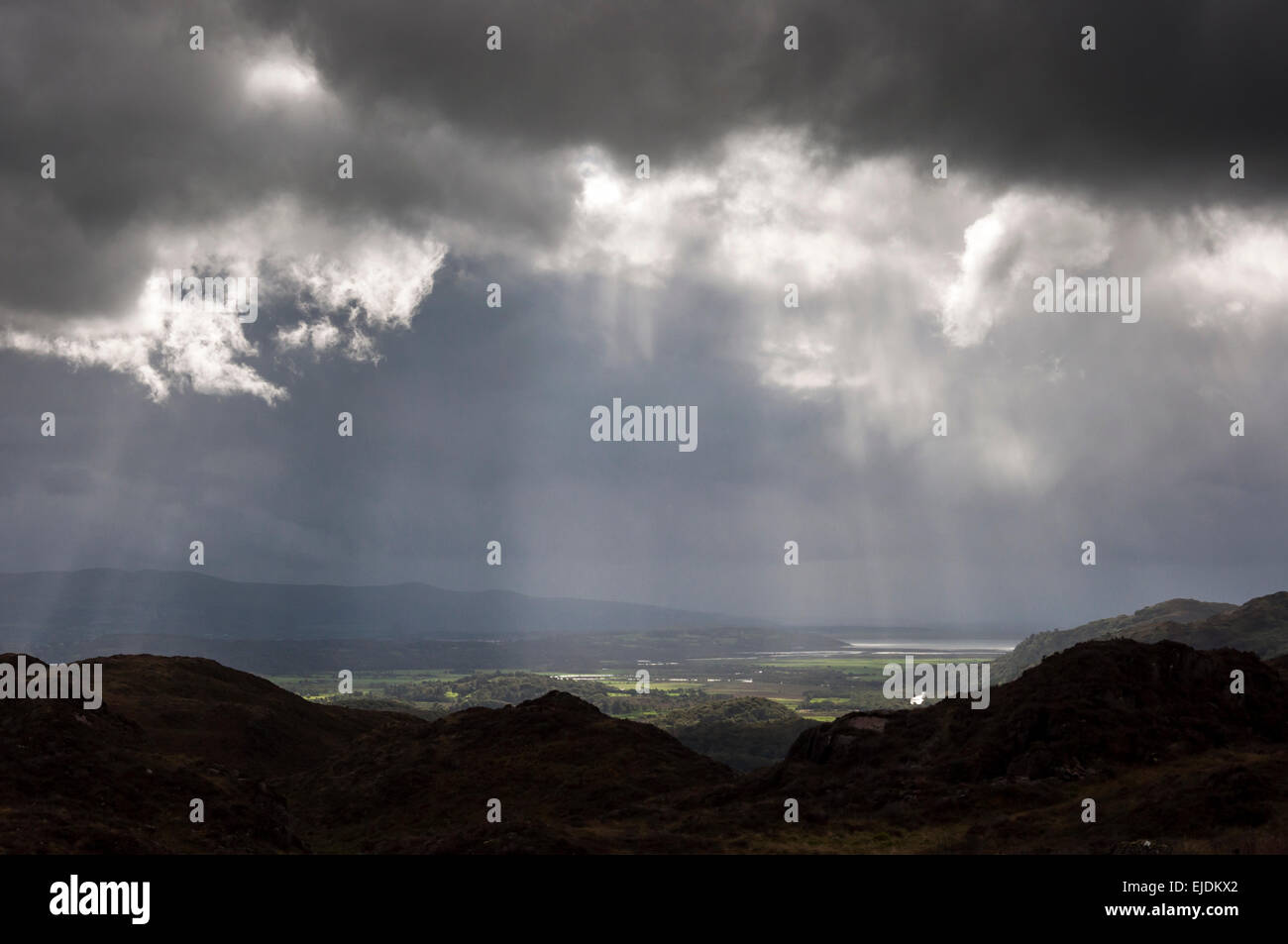 Dramatische Beleuchtung in der Nähe von Bedggelert in Snowdonia, Nordwales. Sonnenstrahlen brechen durch die niedrige Wolke. Stockfoto