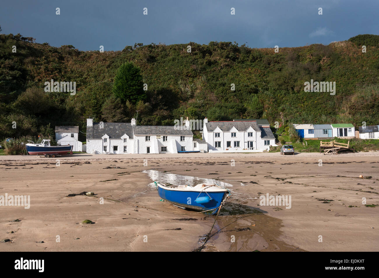 Kleines Boot vor weißen Häusern am Nefyn Strand auf der Halbinsel Leyn, Nordwales. Ein sonniger Morgen. Stockfoto