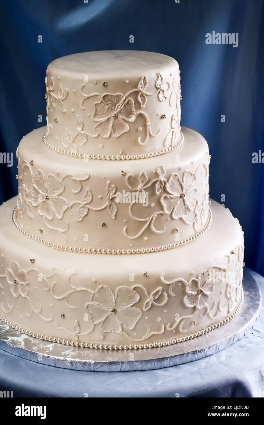 Drei abgestufte Hochzeitstorte abgedeckt Elfenbein Fondant mit Pipe Stickmuster Stockfoto