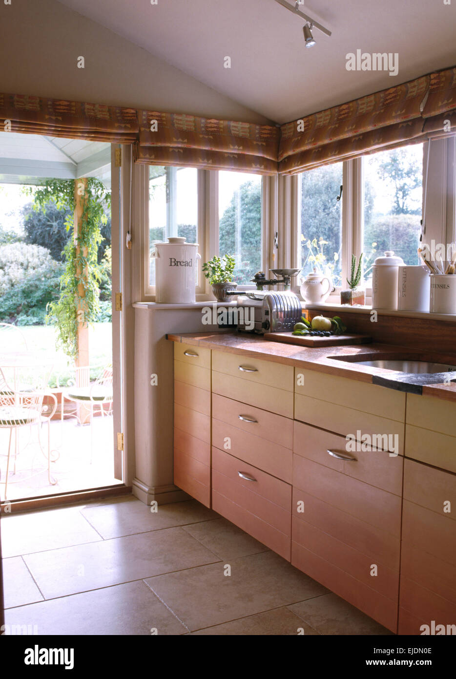 Gemusterte Vorhänge am Fenster und Türen in Küche-Erweiterung Stockfoto