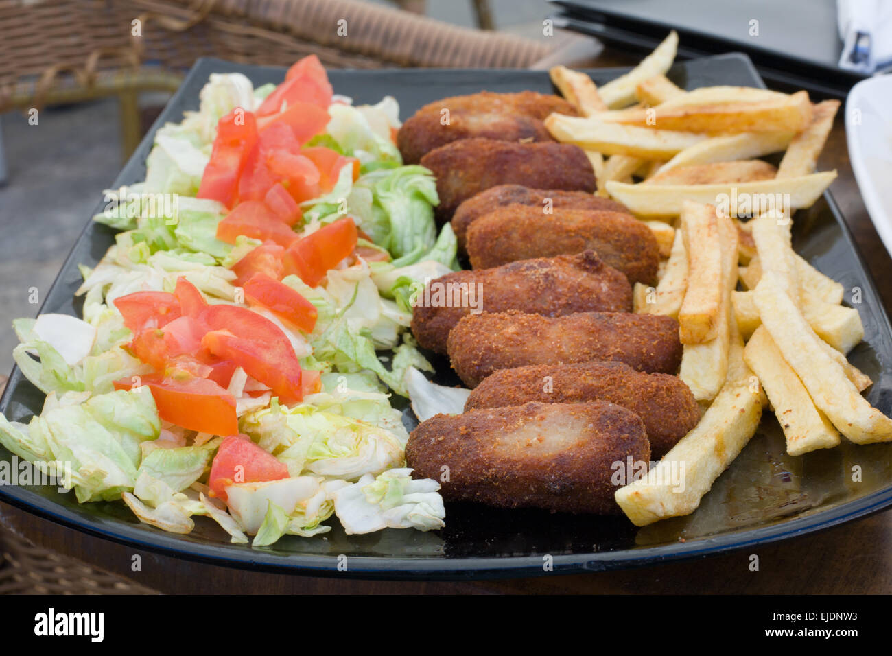 Wurstwaren Schinken spanische Kroketten mit Salat und französische gebratene Kartoffeln Stockfoto