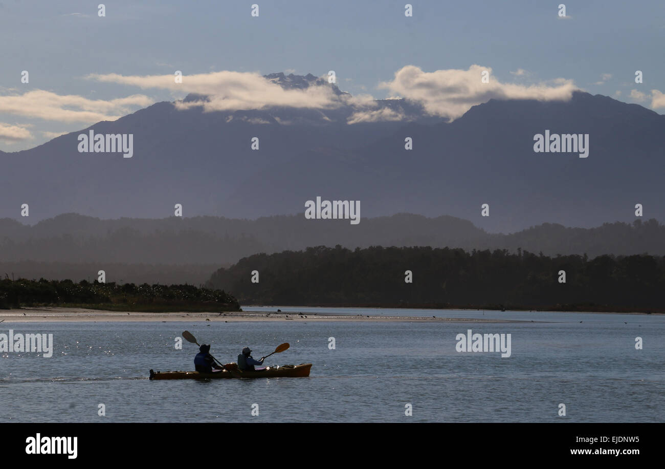 Kajakfahrer Okarito Lagoon Neuseeland mit südlichen Alpen Berge im Hintergrund Stockfoto