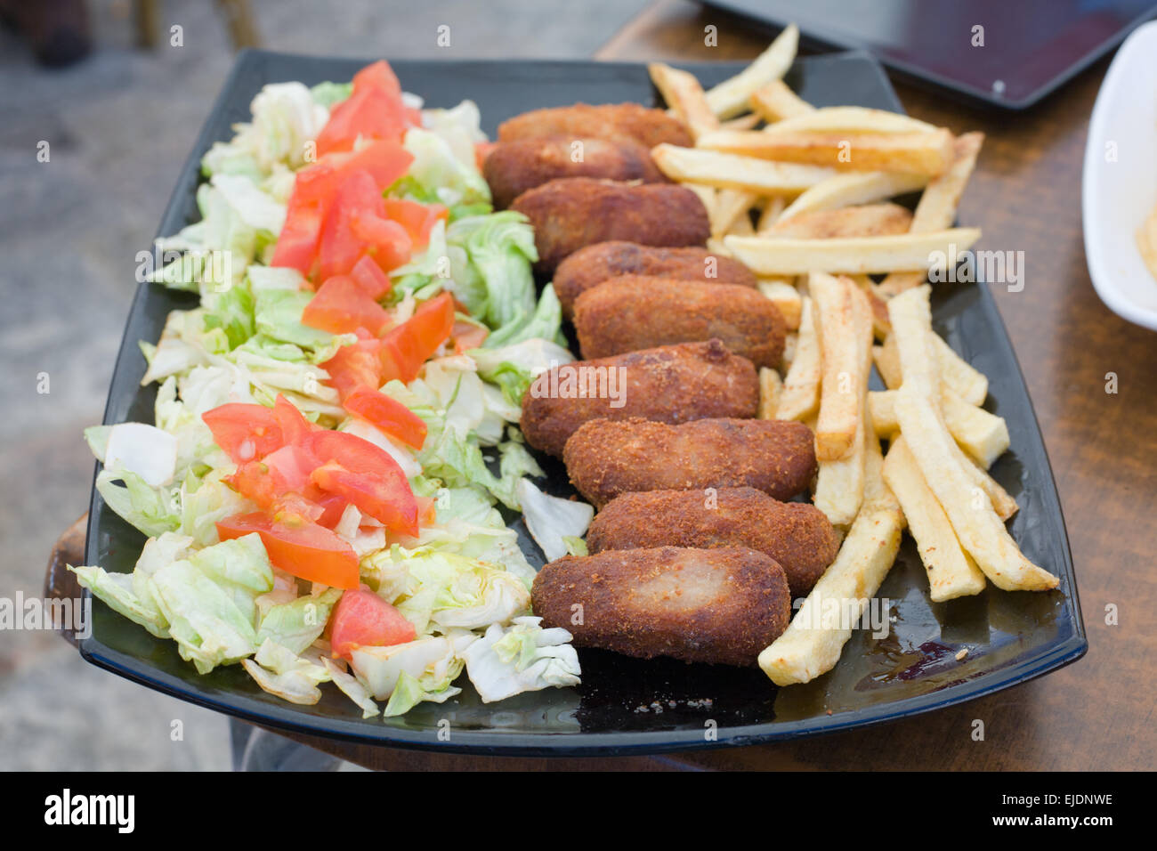 Wurstwaren Schinken spanische Kroketten mit Salat und französische gebratene Kartoffeln Stockfoto