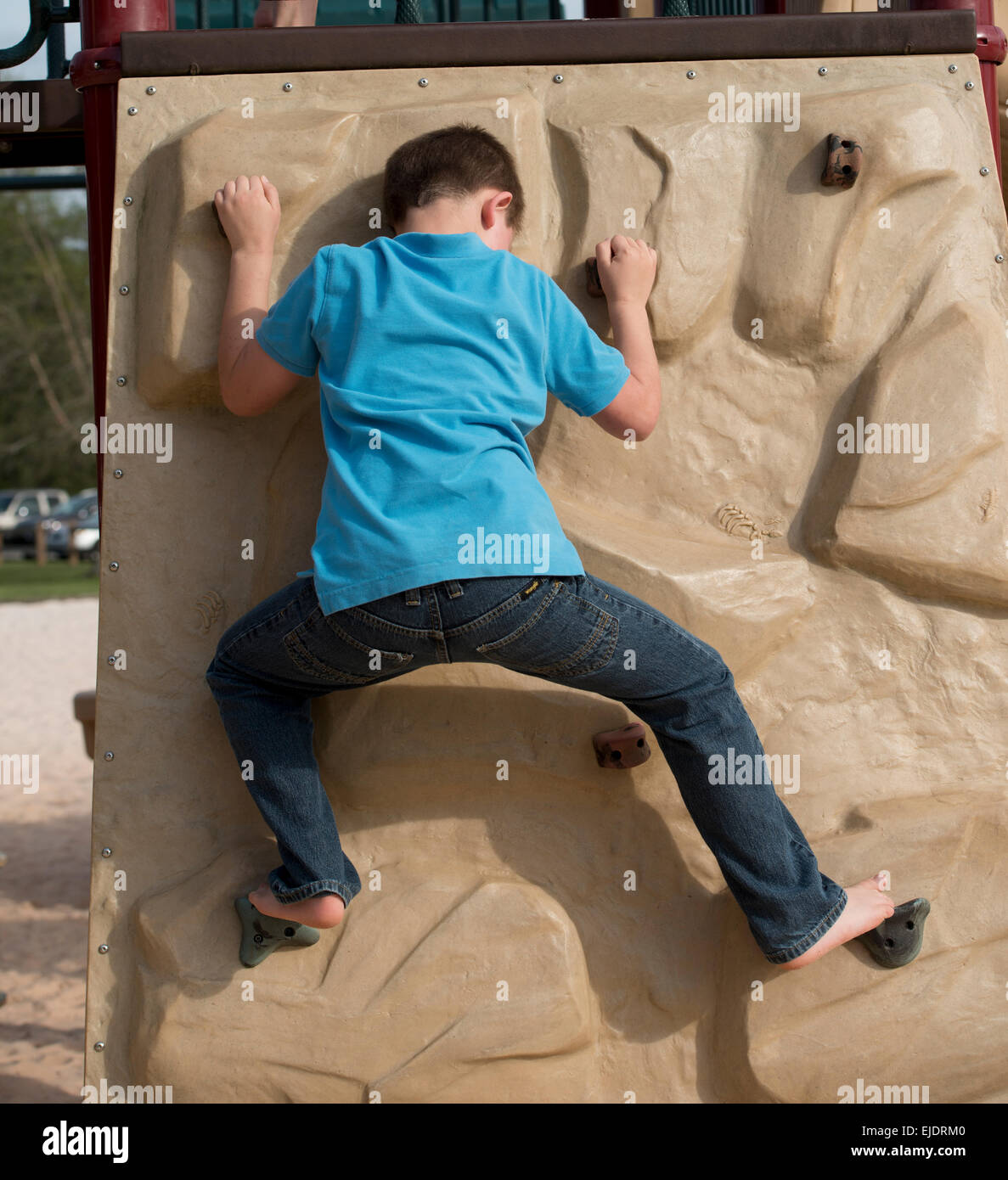 Acht Jahre alter Junge Rock Kletterwand am Park Spielplatz Stockfoto