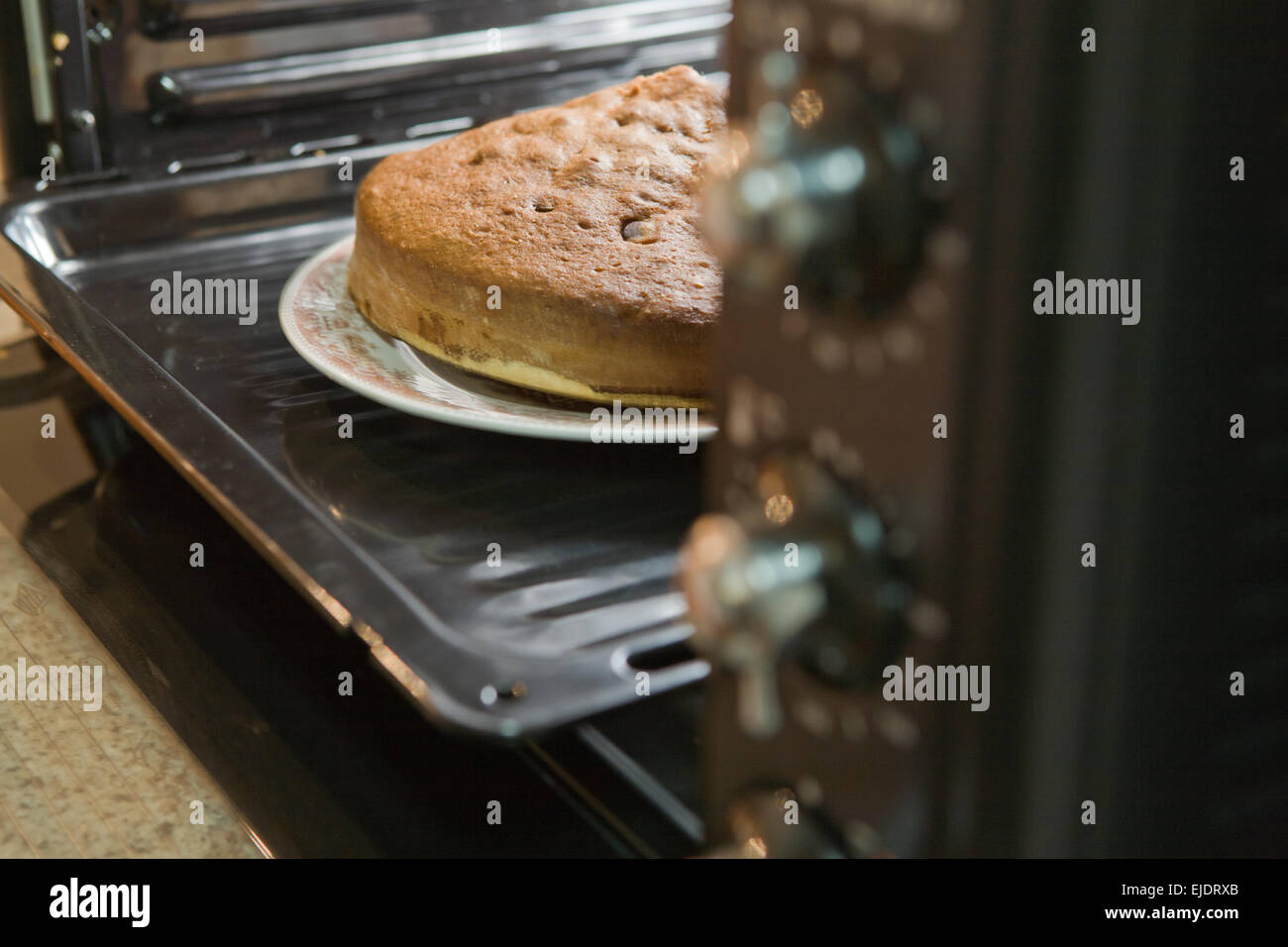 Nahaufnahme von einem hausgemachten Kuchen in Backform im offenen Ofen Stockfoto