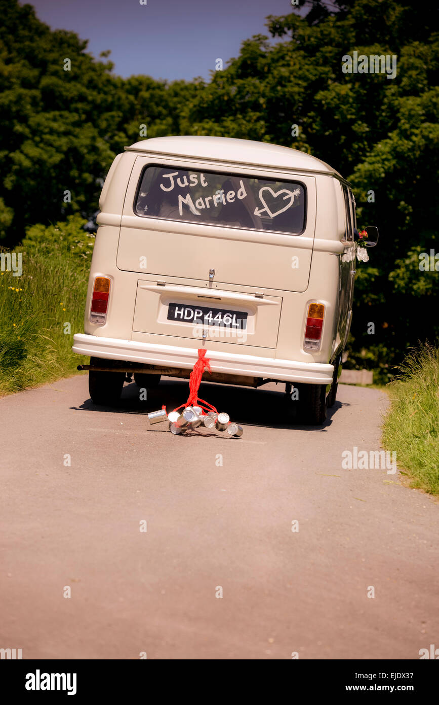 Volkswagen Camper Bus mit gerade im Fenster verheiratet wird mit Dosen an der Rückseite Stoßstange gebunden gefahren. Stockfoto