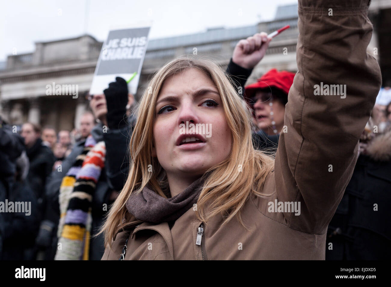 Eine junge Frau singt die französische nationale Hymne auf einer Kundgebung auf dem Trafalgar Square für die Opfer der Charlie Hebdo Terroranschläge Stockfoto