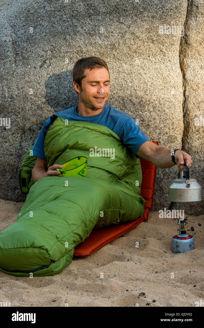 Mann in einem Schlafsack Heizungswasser Stockfoto