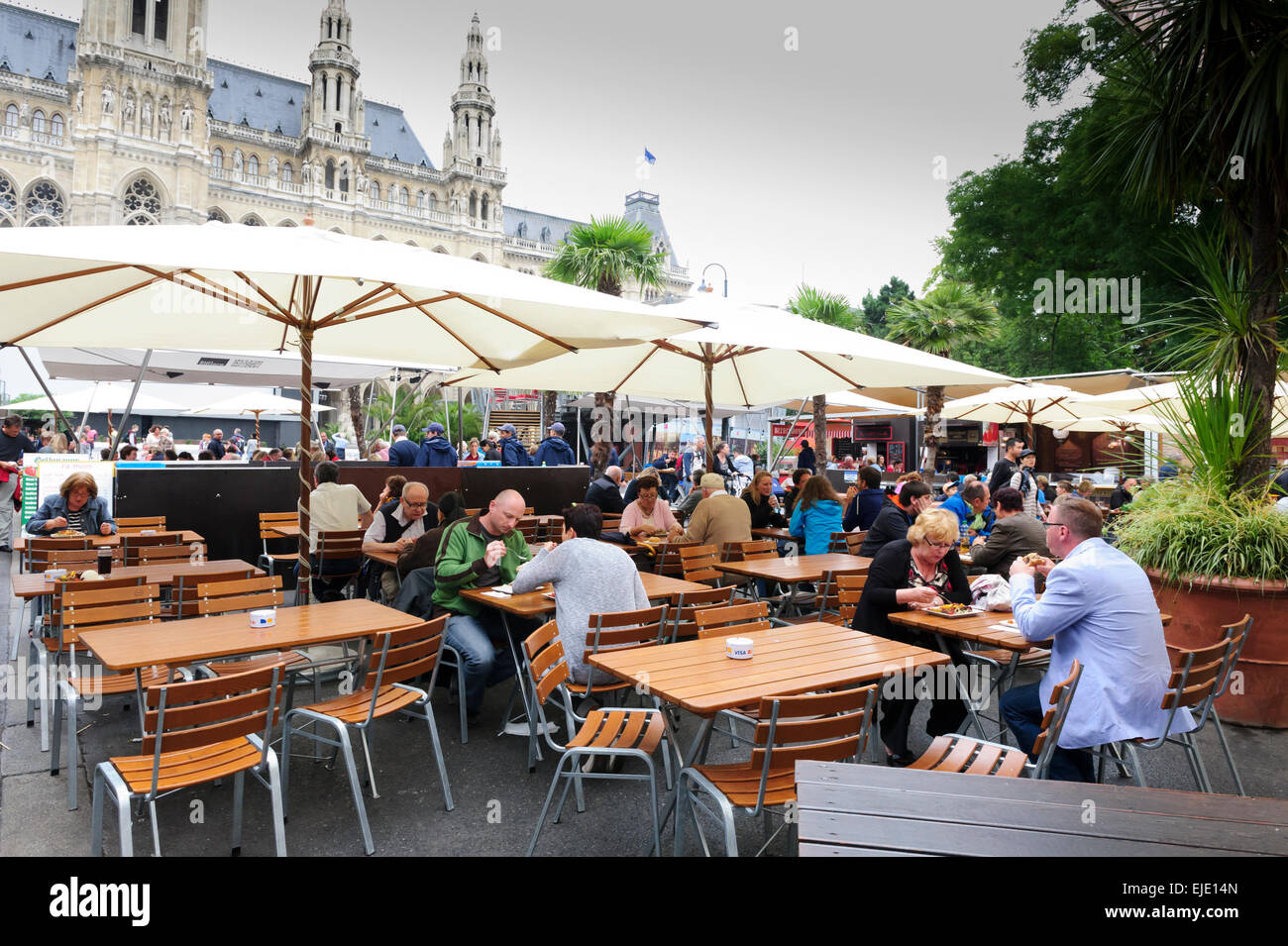 Menschen Essen unter großen Sonnenschirmen vor dem Rathaus in Wien, Österreich. Stockfoto Menschen Essen unter großen Sonnenschirmen vor dem Rathaus in Wien, Österreich. Stockfoto