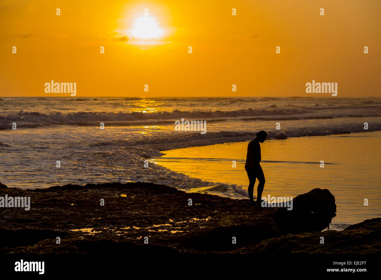 Mann geht auf dem Riff bei Ebbe, Bali Indonesien. Stockfoto