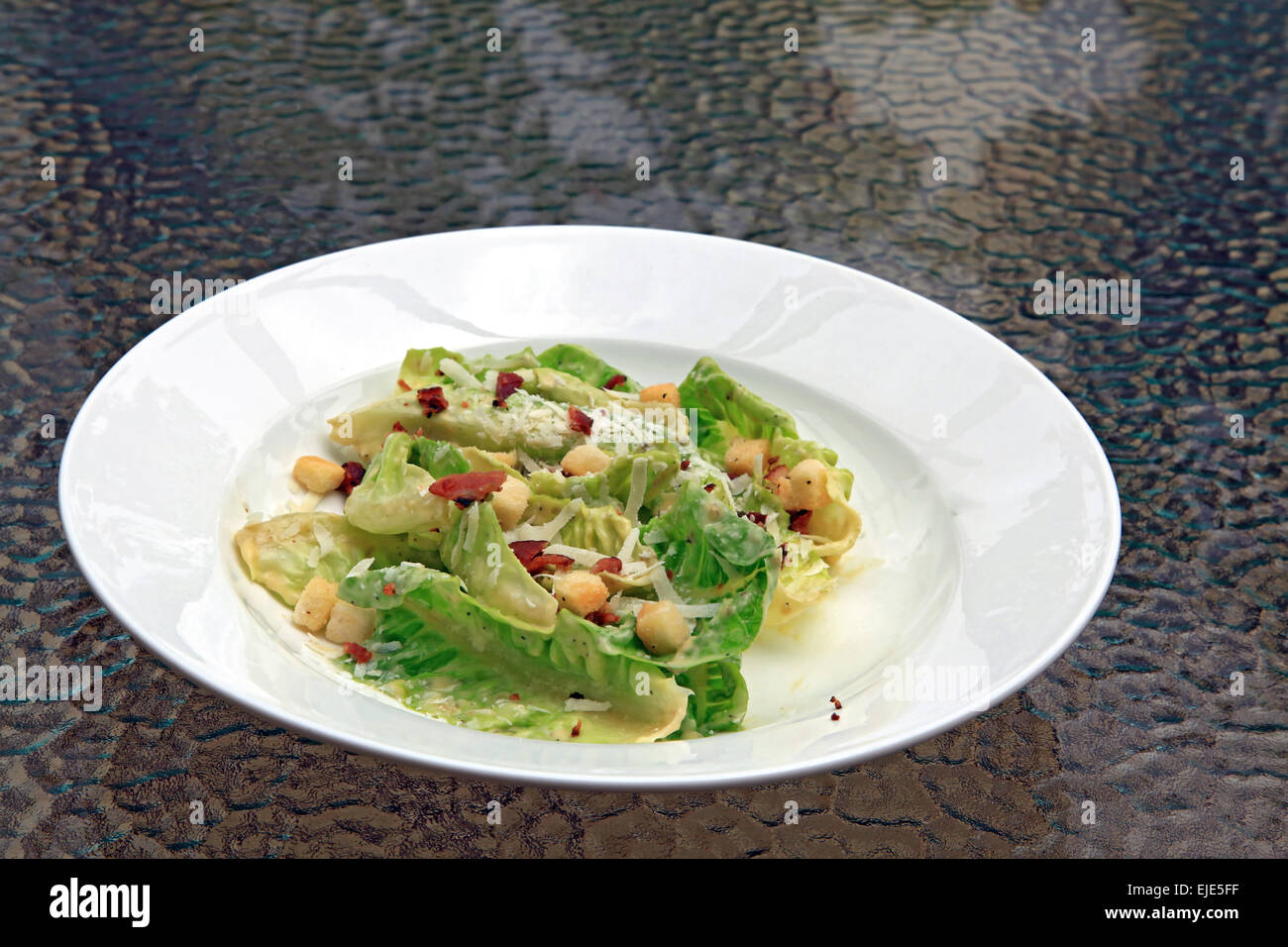 Caesar Salat in weiße Schale auf Glastisch Stockfoto