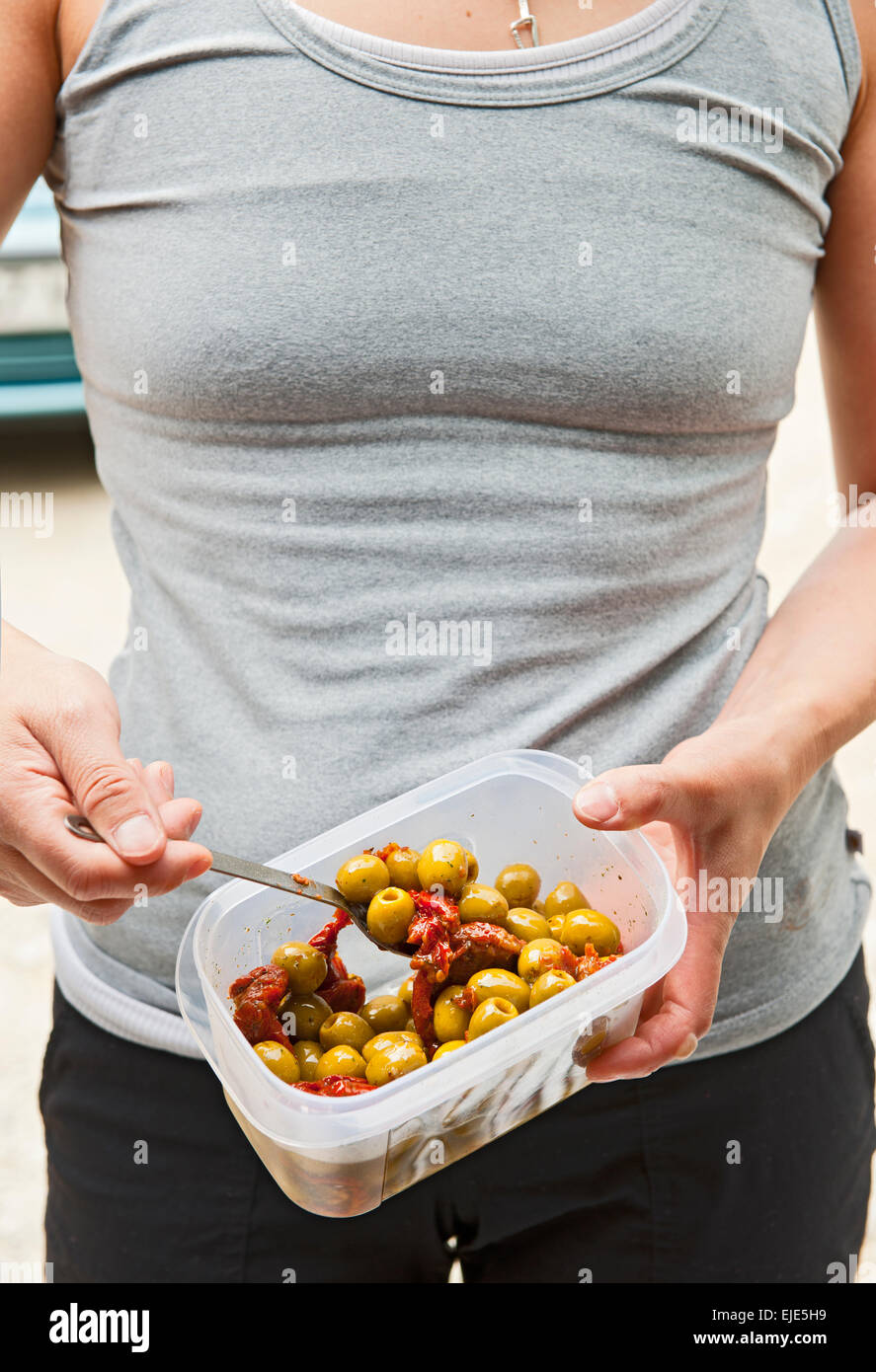 junge Frau Essen marinierte Oliven Stockfoto