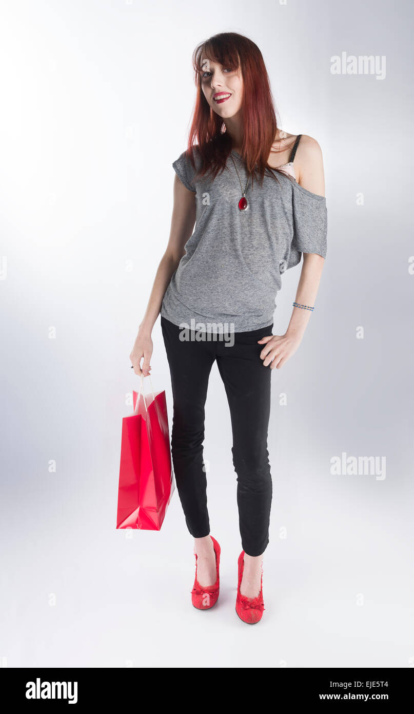 Teenager Frau hält einzelne rote Einkaufstasche Stockfoto