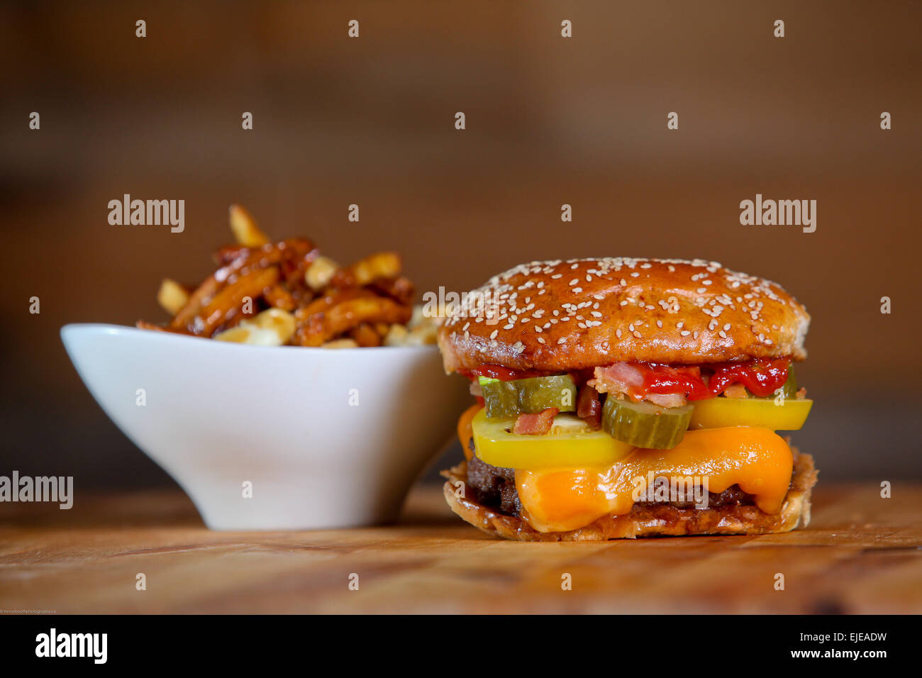 Bacon Cheeseburger mit Beilage Poutine Pommes Frites. Stockfoto
