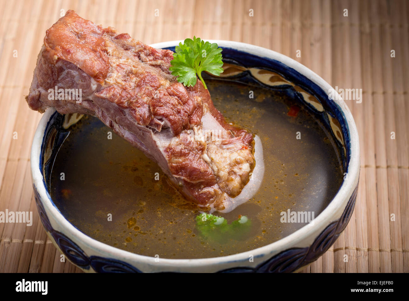 Gemüsesuppe mit geräuchertem Fleisch auf hölzernen Tischdecke Stockfoto