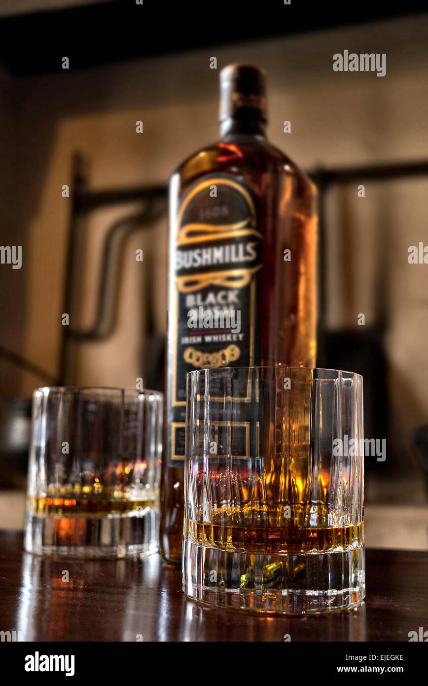 Zwei Gläser von Bushmills Black Bush Whiskey mit Flasche auf einen Balken Stockfoto