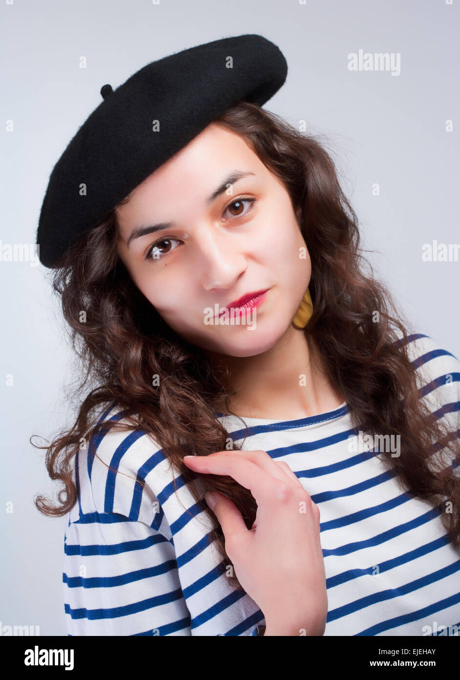 Junge schöne Frau mit französischem Barett und Gestreiftes T-Shirt Stockfoto