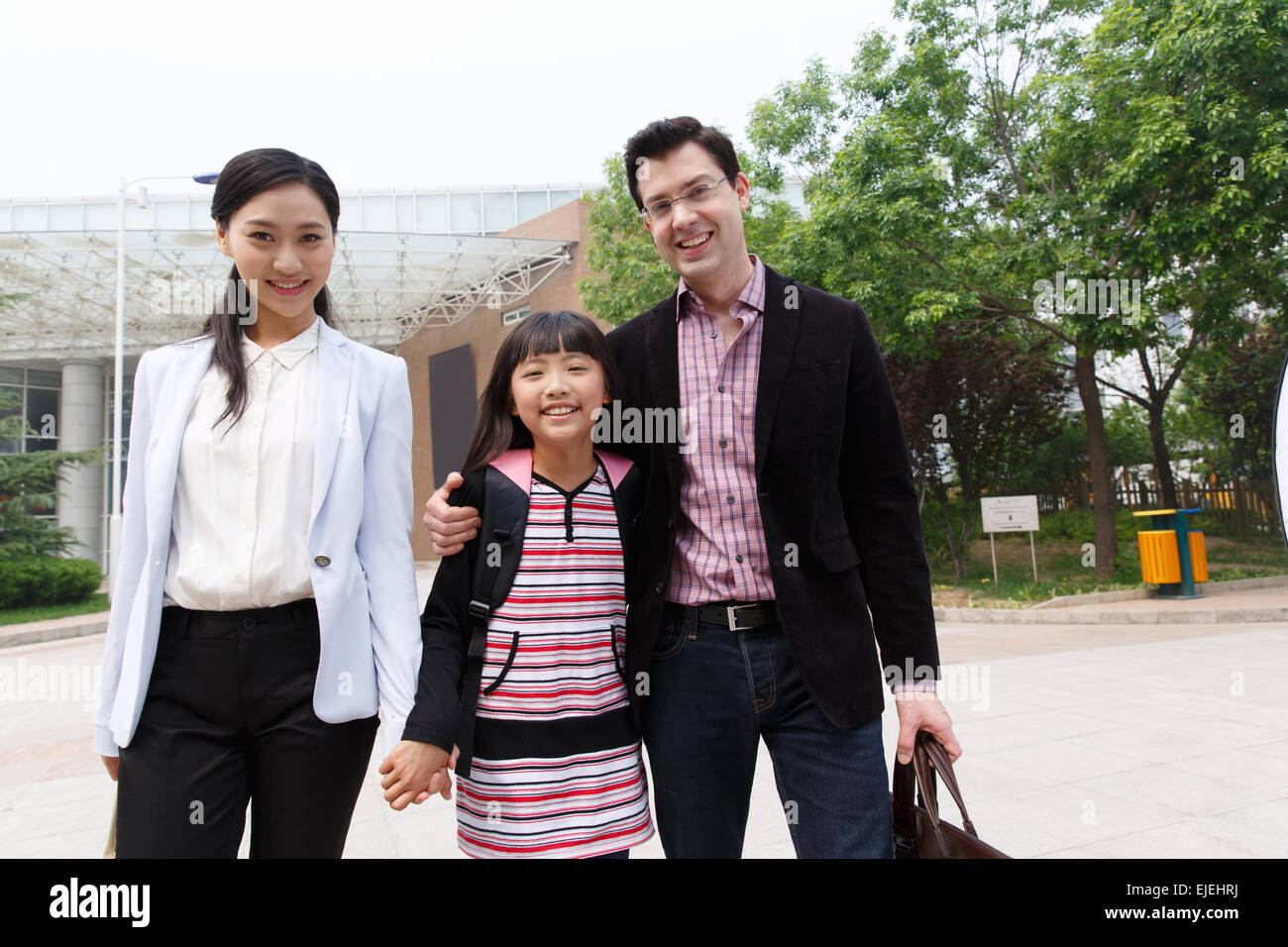 Eine Familie mit drei in dem Schuleingang Stockfoto