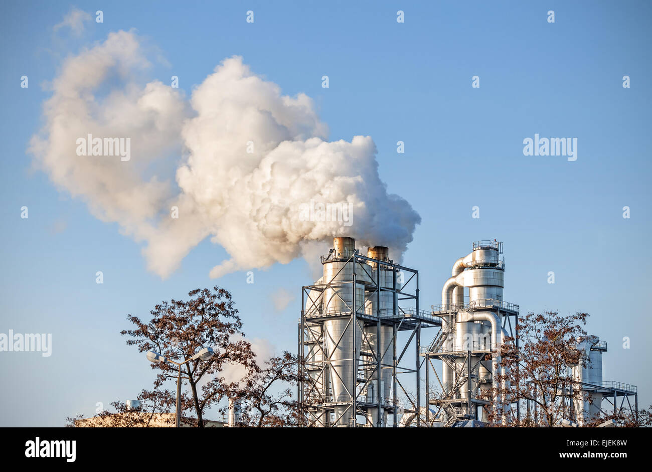 Rauchende Schlote über blauer Himmel, Luft-Verschmutzung-Konzept. Stockfoto