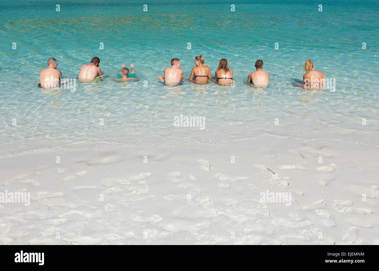 Eine Gruppe von jungen Männern und Frauen, die im Meer entspannen Stockfoto