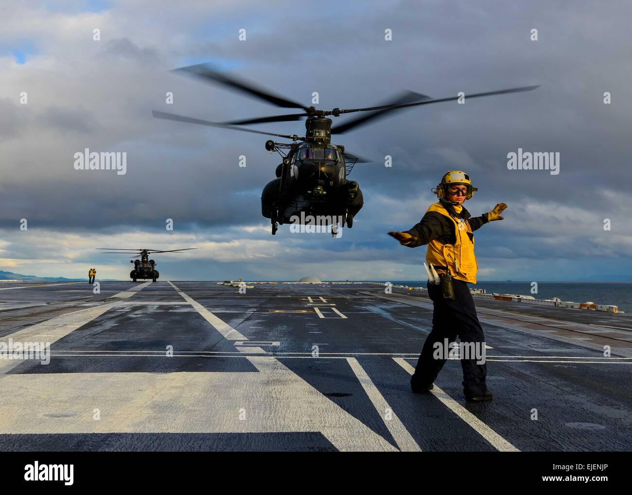 Ein US-Marine Seemann führt einen Sicherheits-Check vor Signalisierung für den Take off eine Armee CH-47 Chinook aus dem Flugdeck der USS John C. Stennis 23. März 2015 in den Pazifischen Ozean. Stockfoto