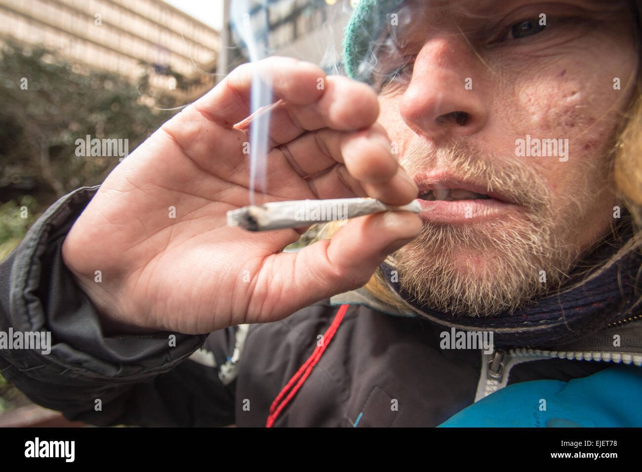 Ein Mann, der ein Joint mit Gewürz raucht, ein legaler High Stockfoto