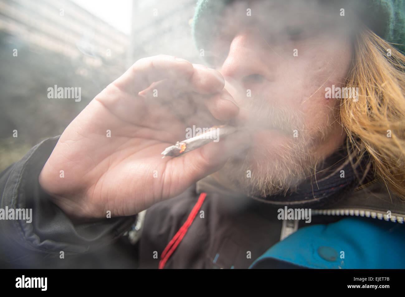 Ein Mann, der ein Joint mit Gewürz raucht, ein legaler High Stockfoto